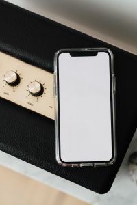 Kaboompics - Black speaker on marble table, white wall, mobile phone - mockup