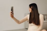 Kaboompics - Woman Taking a Selfie with an Outstretched Smartphone at Home