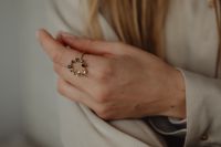 Kaboompics - Woman's Hand with Ornate Gold Ring on Tan Silk Shirt