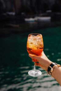 Kaboompics - Spritz Glass and Watch against a Blurred Waterfront