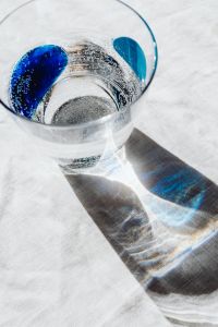 Kaboompics - Angled Top-Down Glass of Water with Blue Details, Abstract Light and Shadow Background