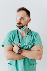 Kaboompics - Doctor Wearing Clear Safety Goggles with a Mask under His Chin, Vertical Medical Portrait