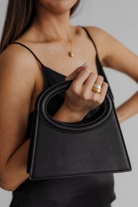 Kaboompics - Black Handbag Held with Ringed Hand and Black Satin Top