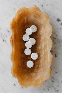 Kaboompics - White Tablets Arranged on an Amber Shell