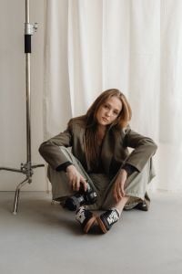 Kaboompics - Young Female Photographer Sitting with DSLR in Neutral Studio