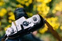 Kaboompics - Woman with vintage camera in the field of blooming rapes