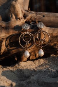 Kaboompics - Gold-Tone Drop Earrings with Pearls on Driftwood and Sand