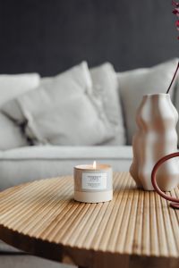 Kaboompics - Woman Lighting a Candle on a Wooden Table