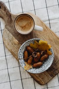 Kaboompics - Coffee Cup and Bowl of Acorns on a Wooden Board