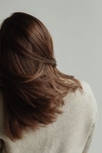 Kaboompics - Wind-Swept Brown Hair across a Beige Knit Shoulder