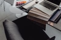 Kaboompics - MacBook, Neutral Upholstery Samples and Swatch Books on a Black Worktable