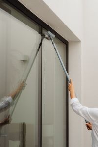 Kaboompics - Woman Washing a Large Glass Window with a Squeegee