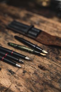 Kaboompics - Black and Green Fountain Pens Beside a Leather Pen Case