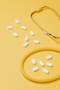 Kaboompics - Close-Up of White Tablets and Yellow Stethoscope, Bright Medical Care Background