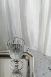 Kaboompics - Ribbed Wine Glass on Silver Tray and Speckled Gray Stone