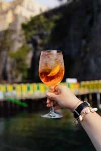 Kaboompics - Aperol Spritz Glass against a Soft-Focus Rocky Coast