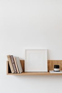 Kaboompics - Vertical Frame Mockup and Books Styled on a Wooden Wall Shelf