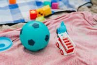 Kaboompics - Blue Toy Ball and Cars on a Pink Beach Towel for Children's Summer Play