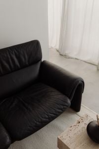 Kaboompics - Black Leather Armchair beside Travertine Coffee Table