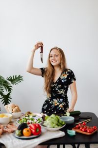 Kaboompics - Smiling Woman Posing with a Kitchen Knife and Fresh Salad Ingredients