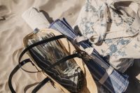 Kaboompics - Straw Bag, Hat and Folded Beach Clothing on the Sand