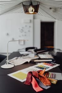 Kaboompics - Design Studio Flat Lay with Material Boards, Draped Textiles, Desk Lamp and Laptop