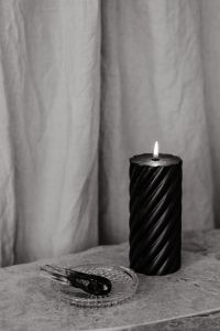 Kaboompics - Black Spiral Candle and Smoldering Palo Santo on Marble, Warm Moody Still Life