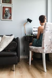 Stylish Home Office Workspace With Laptop, Floral Chair And Cat
