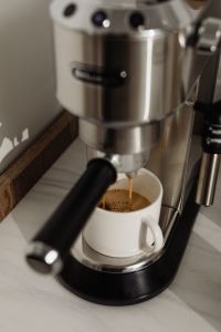Kaboompics - Fresh Espresso Crema in a White Mug Under Coffee Machine