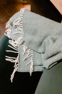 Pastel green blanket on a velour dark green armchair
