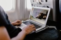 Kaboompics - Unrecognizable man with notebook sitting inside an airplane