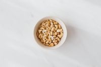 Kaboompics - Overhead White Bowl of Cashews on Marble with Copy Space for Food Design