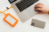 Kaboompics - Man works on a computer at his desk, mobile phone, portable hard drive