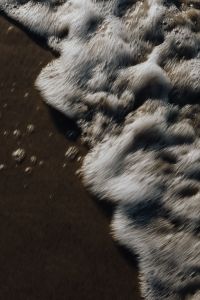 Kaboompics - Vertical White Surf Curling onto Dark Wet Sand, Beach Texture