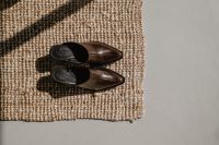 Kaboompics - Brown and Black Leather Loafers on Woven Rug