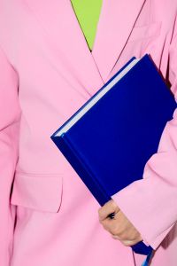 Kaboompics - Person in Pink Suit Holding Blue Notebooks