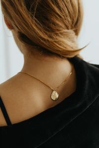 Kaboompics - Gold Pendant Necklace on Woman's Bare Shoulder