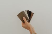 Kaboompics - Hand Holding Earthy Tone Paint Color Swatches for Interior Design