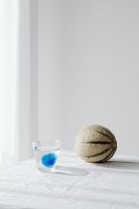 Kaboompics - Glass of Water and Whole Cantaloupe on White Linen, Fresh Summer Drink Content