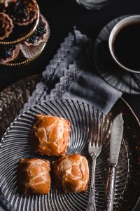 Sweet Cream Cheese Buns with Coffee on a Dark Dessert Table