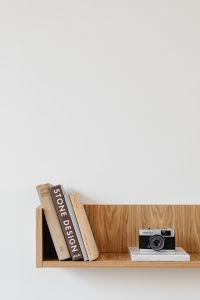 Kaboompics - Vertical Still Life of Vintage Camera and Books on Wooden Shelf