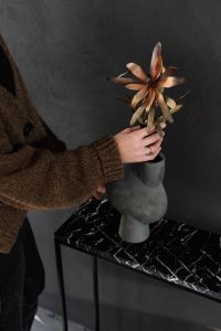Kaboompics - Arranging Dried Flowers in a Gray Vase on a Black Marble Console Table