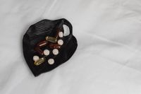 Kaboompics - Mixed Vitamins and Tablets on a Black Leaf on White Fabric