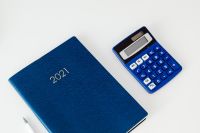 Kaboompics - Navy 2021 Planner Beside Blue Calculator and Pen