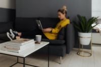 Kaboompics - Cozy Living Room Remote Work with Laptop, Books, Coffee and Houseplant