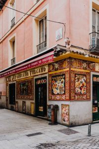Kaboompics - Vertical Spanish Restaurant Corner with Painted Tilework, Menu Posters and Pink Facade