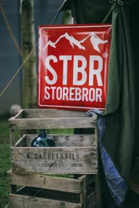 Kaboompics - Red STBR Storebror Sign Hanging Above Wooden Crates at an Outdoor Market Stall