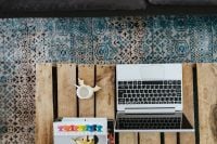 Kaboompics - Silver laptop and a white mug on a wooden box table