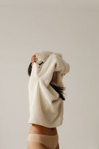 Kaboompics - Neutral Lifestyle Portrait of a Woman Partly Hidden Behind Chunky Knitwear