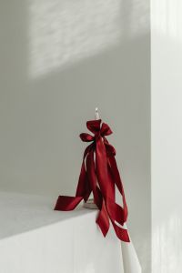Kaboompics - Minimal White Candle with Red Satin Bow, Close-Up